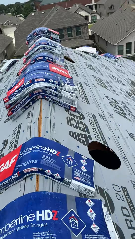 GAF Timberline HDZ shingle bundles staged along a roof ridge over synthetic underlayment